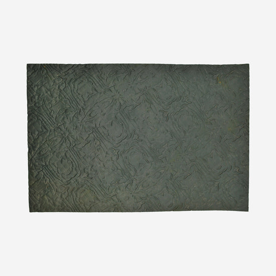 Textured mat that has a wrinkled cloth pattern.